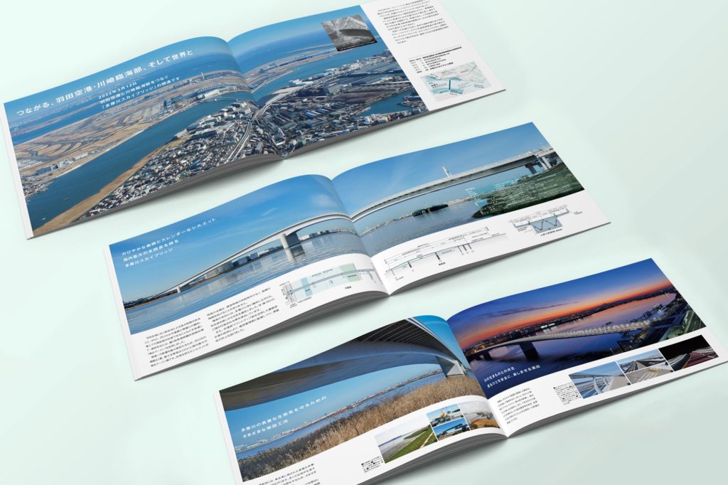 多摩川スカイブリッジの竣工パンフレットの中面。空撮や船上から撮影した全景写真、橋の構造図、ライトアップされた夕景などが美しくレイアウトされている。橋の特長や技術的なポイントがわかりやすく解説され、開通式典で関係者に配布された公式資料。