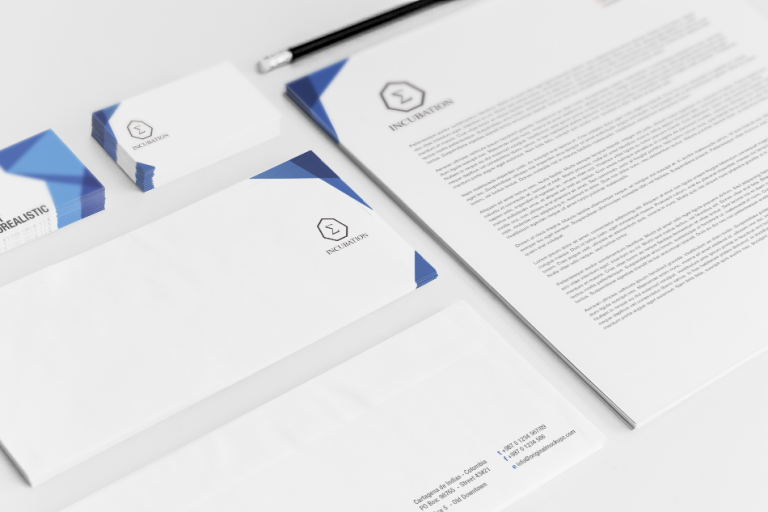 IT企業向けのブランディング用ステーショナリーセット。名刺、封筒、レターヘッド、企業ロゴが統一デザインで配置され、シンプルかつ洗練されたブルーのグラフィックがアクセント。中央には六角形のフレームに囲まれた『Σ（シグマ）』のロゴと『INCUBATION』の文字が配置され、スタートアップの成長やイノベーションを象徴するデザイン。