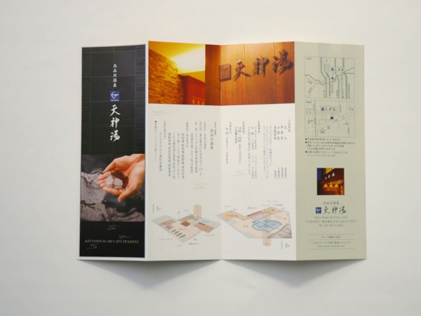 デザイナーズ銭湯『天神湯』のパンフレット。黒を基調とした表紙には、温泉の湯を手にすくう写真を配置し、高級感のある和モダンなデザイン。内部には施設案内や浴場マップ、アクセス情報を掲載し、落ち着いた雰囲気を演出。東京都内のリラックスできる温泉施設を紹介。