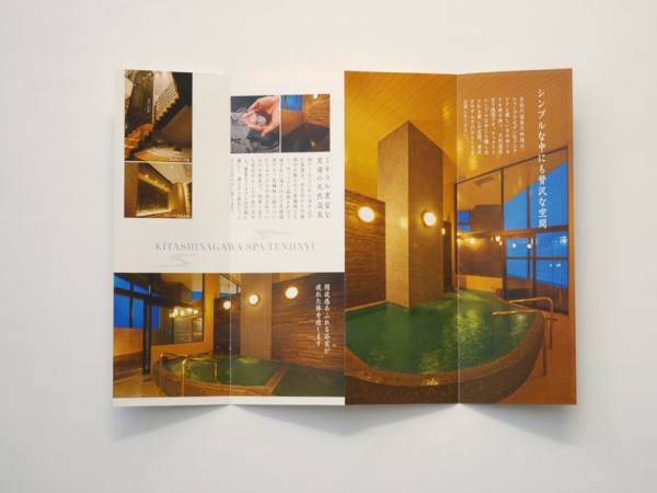 デザイナーズ銭湯『天神湯』のパンフレット内部ページ。シンプルで高級感のある温泉施設の紹介。広々とした浴槽は木とタイルでデザインされ、大きな窓からは開放的な景色が楽しめる。モダンな和の雰囲気を演出し、東京都内でリラックスできる銭湯をアピール。上質な空間で癒しのひとときを提供。