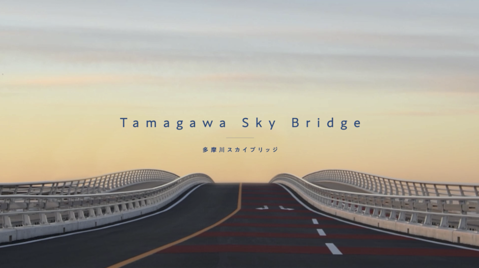 多摩川スカイブリッジの開通記念動画制作。東京都大田区羽田と神奈川県川崎市殿町を結ぶ新たな橋梁の建設工程を記録。2022年春の一般供用開始を記念し、工事関係者向けに特別映像を制作。日の出前の船上撮影や朝焼けに染まる空、橋の上の景観、人々が橋を楽しむシーンを収録。